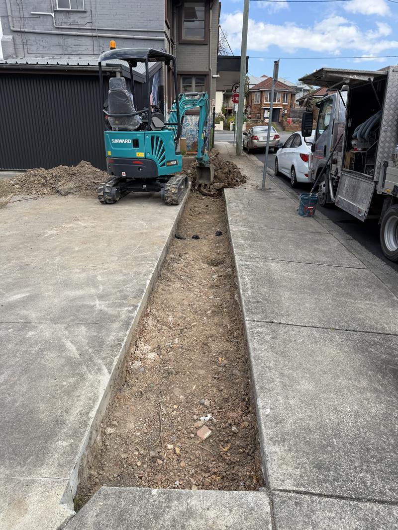 Trench cut along a driveway, tipper waiting