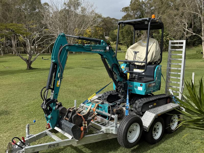 The Sunward SWE18UF 1.8-tonne excavator loaded on its trailer, buckets stacked on the drawbar
