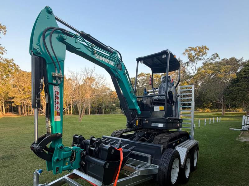 The Sunward SWE25UF 2.7-tonne excavator on its tandem trailer, buckets strapped down beside the boom