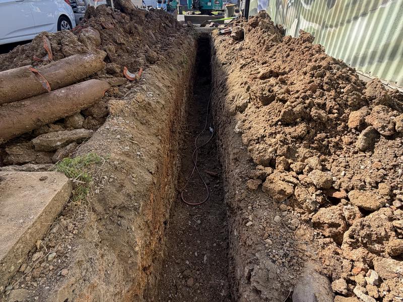 A narrow service trench run the length of a side boundary